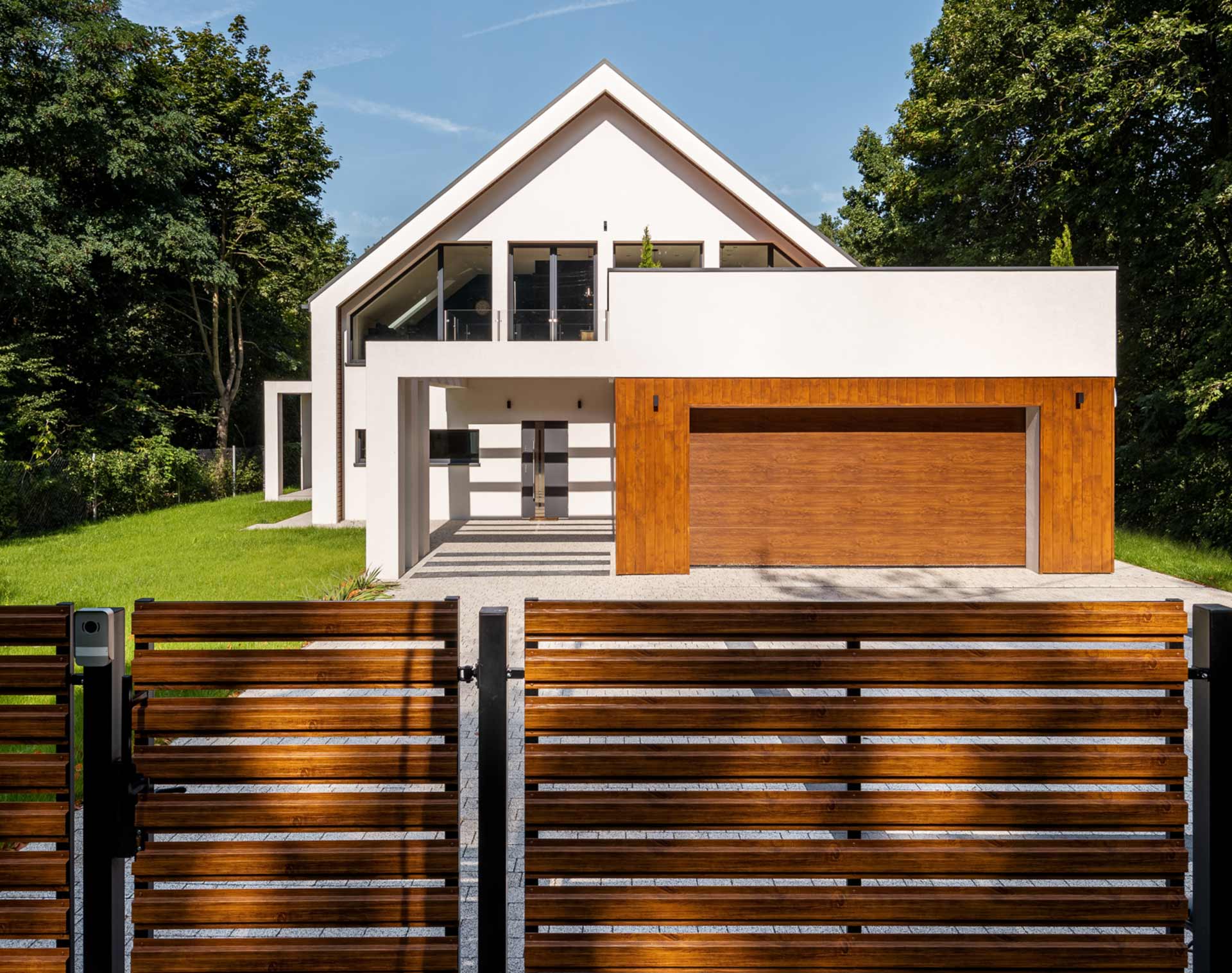 Zaun und Gartentor aus Holz vor einem modernen Einfamilienhaus